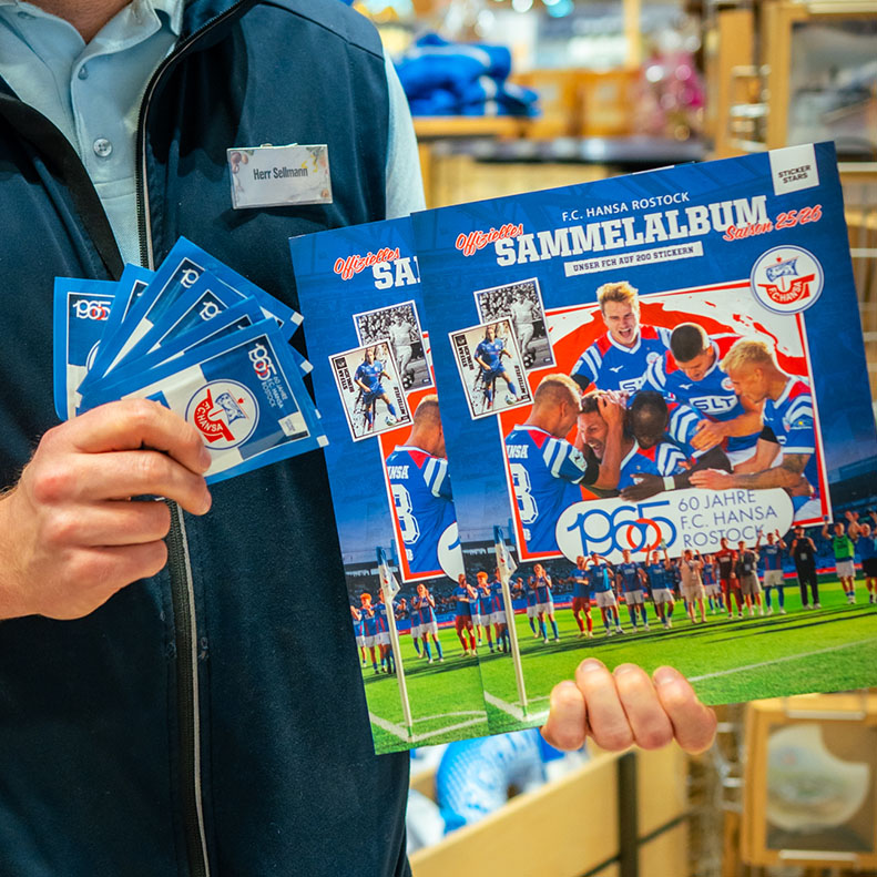 Mitarbeiter des E center Warnow Parks zeigt das Hansa Rostock-Sammelalbum.