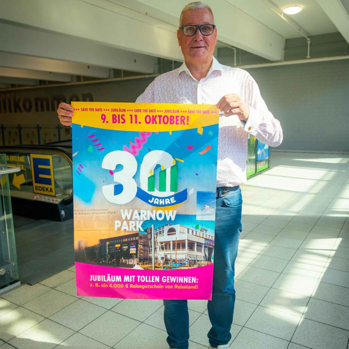 Frank Middendorf hält das Plakat zum 30. Jubiläum des Warnow Parks.