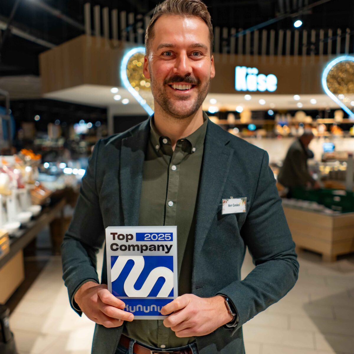 Stephan Cunäus und das Top Company Siegel von kununu im E center Warnow Park.