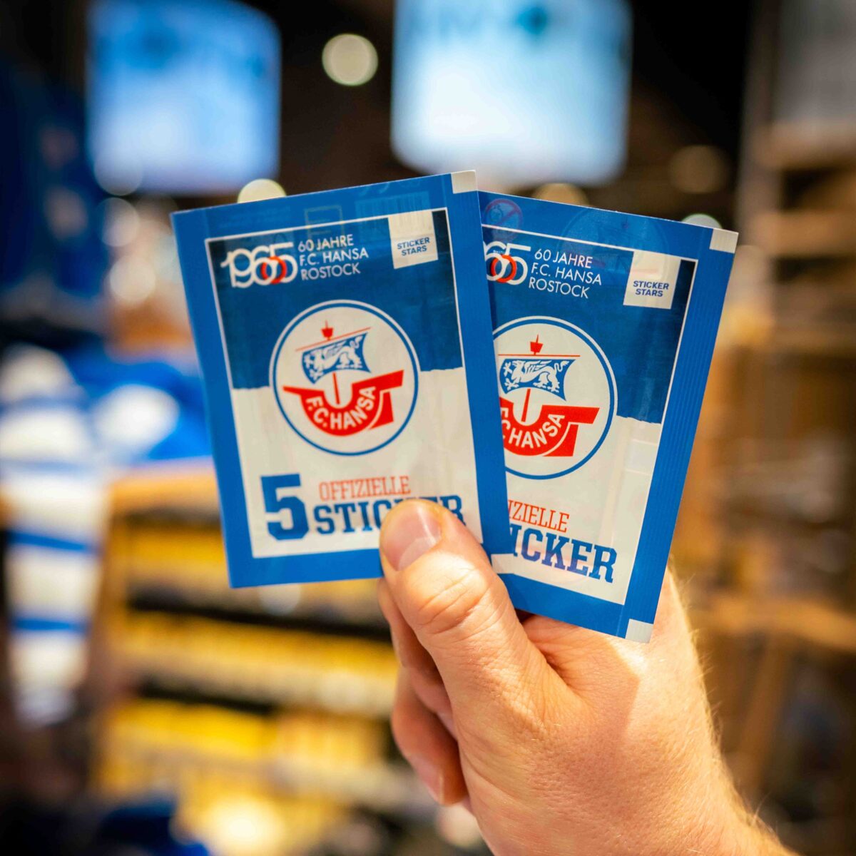 Mitarbeiter des E center Warnow Parks zeigt die Stickerpäckchen.