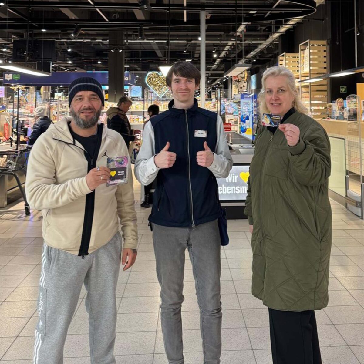 Ein Mitarbeiter mit einem Gewinnerpaar der E center Warnow Park Schnitzeljagd.
