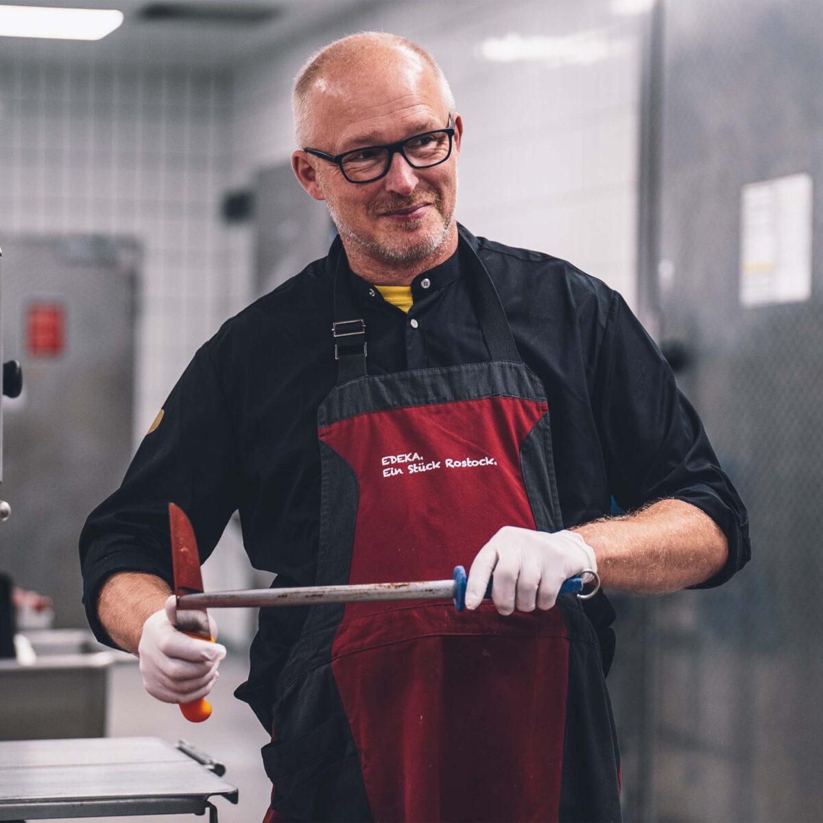 Ein freundlicher Mitarbeiter des E center Warnow Parks in der Fleischerei.